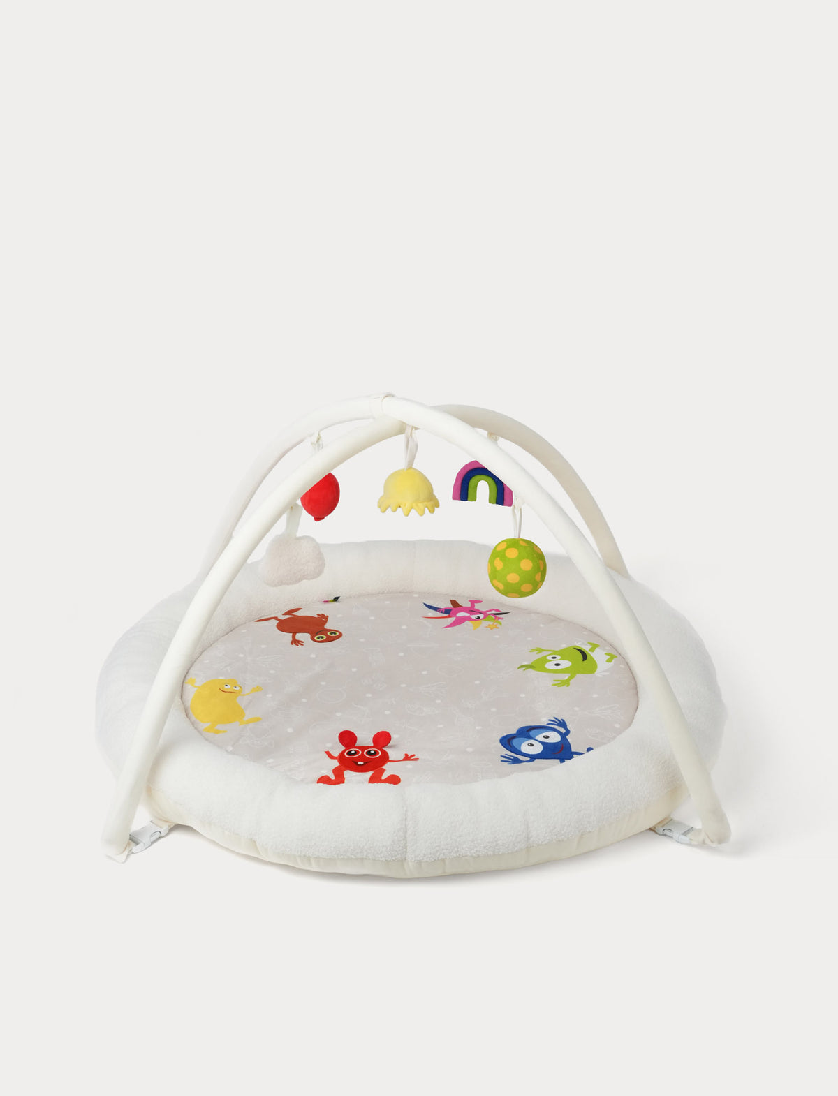 A baby sensory Babblarna play gym  The set includes a round white plush play mat decorated with colorful characters. White arch overhead with hanging sensory toys in red, yellow, rainbow, green, and pink, and a matching white padded base.