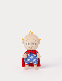 Plush toy with a red cape and blue outfit with star patterns on a white background