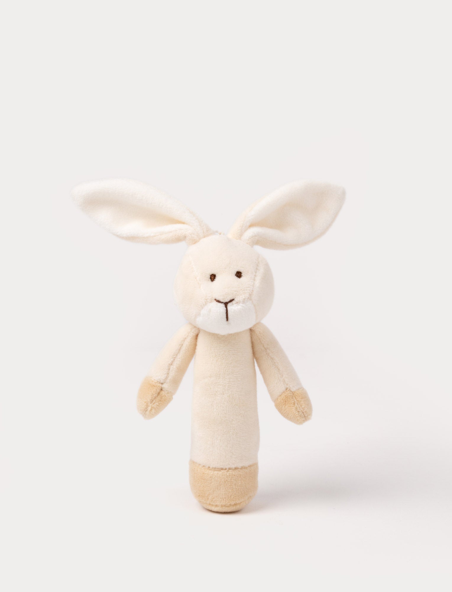  Image of Soft plush bunny rattle with a light beige body, long floppy ears, embroidered eyes, and white accents on the muzzle and base.