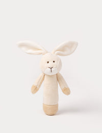 Soft plush bunny rattle with a light beige body, long floppy ears, embroidered eyes, and white accents on the muzzle and base.