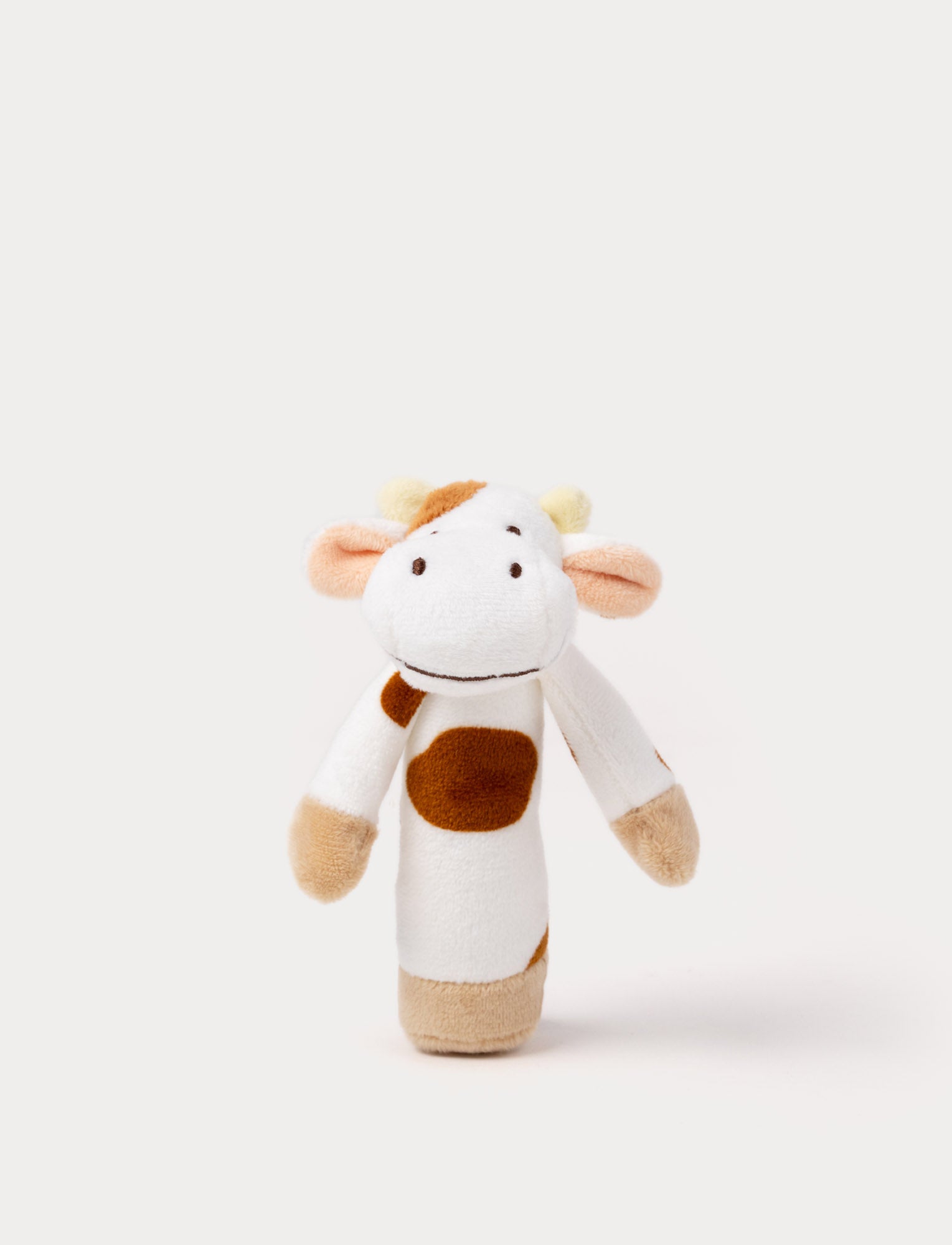  Image of A white and brown cow-shaped rattle with an easy-to-grip design and gentle rattling sound.