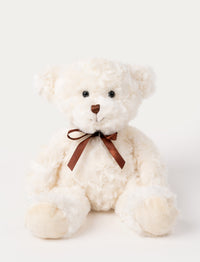White teddy bear with a brown bow on a light gray background