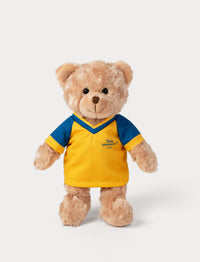 Stuffed teddy bear toy wearing a yellow and blue football shirt 