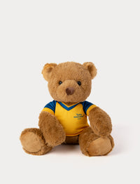 Stuffed teddy bear toy wearing a yellow and blue football shirt 