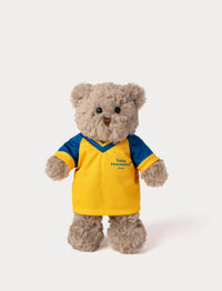 Stuffed teddy bear toy wearing a yellow and blue football shirt 