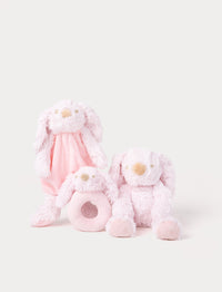 Set of three pink bunny plush toys, including a comfort blanket, a rattle, and a soft stuffed rabbit.