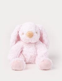 A soft pink plush bunny with floppy ears, a beige nose, and golden-stitched eyes.