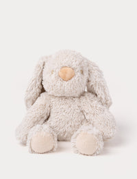 A soft beige plush bunny with floppy ears, a brown nose, and golden-stitched eyes