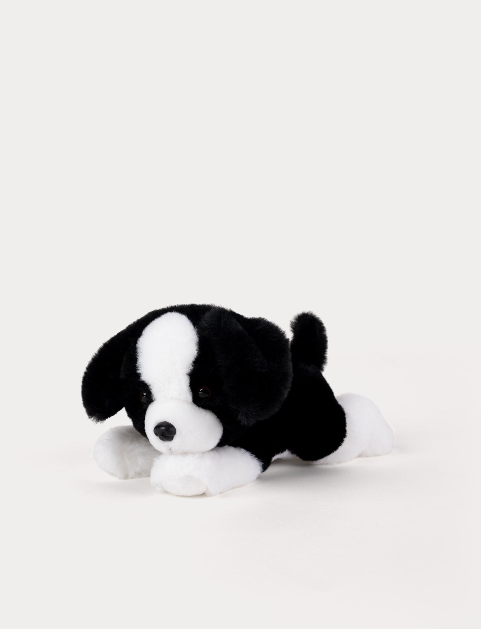  Image of Black and white stuffed dog toy on a light gray background