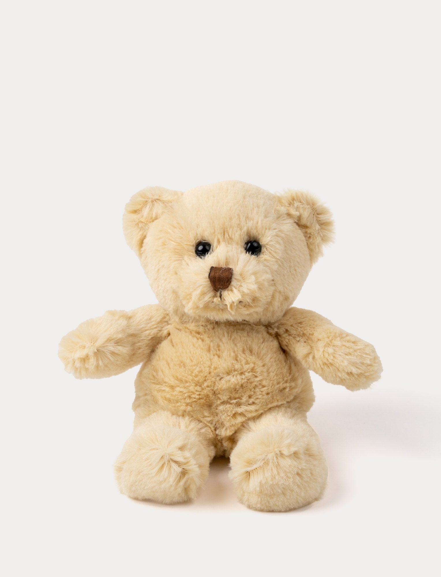  Image of Soft beige teddy bear plush with round ears, a brown nose, and shiny black eyes.