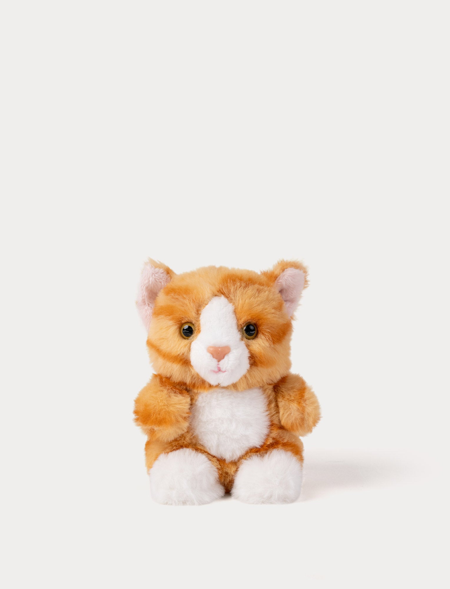  Image of Plush toy cat with orange and white fur on a light gray background