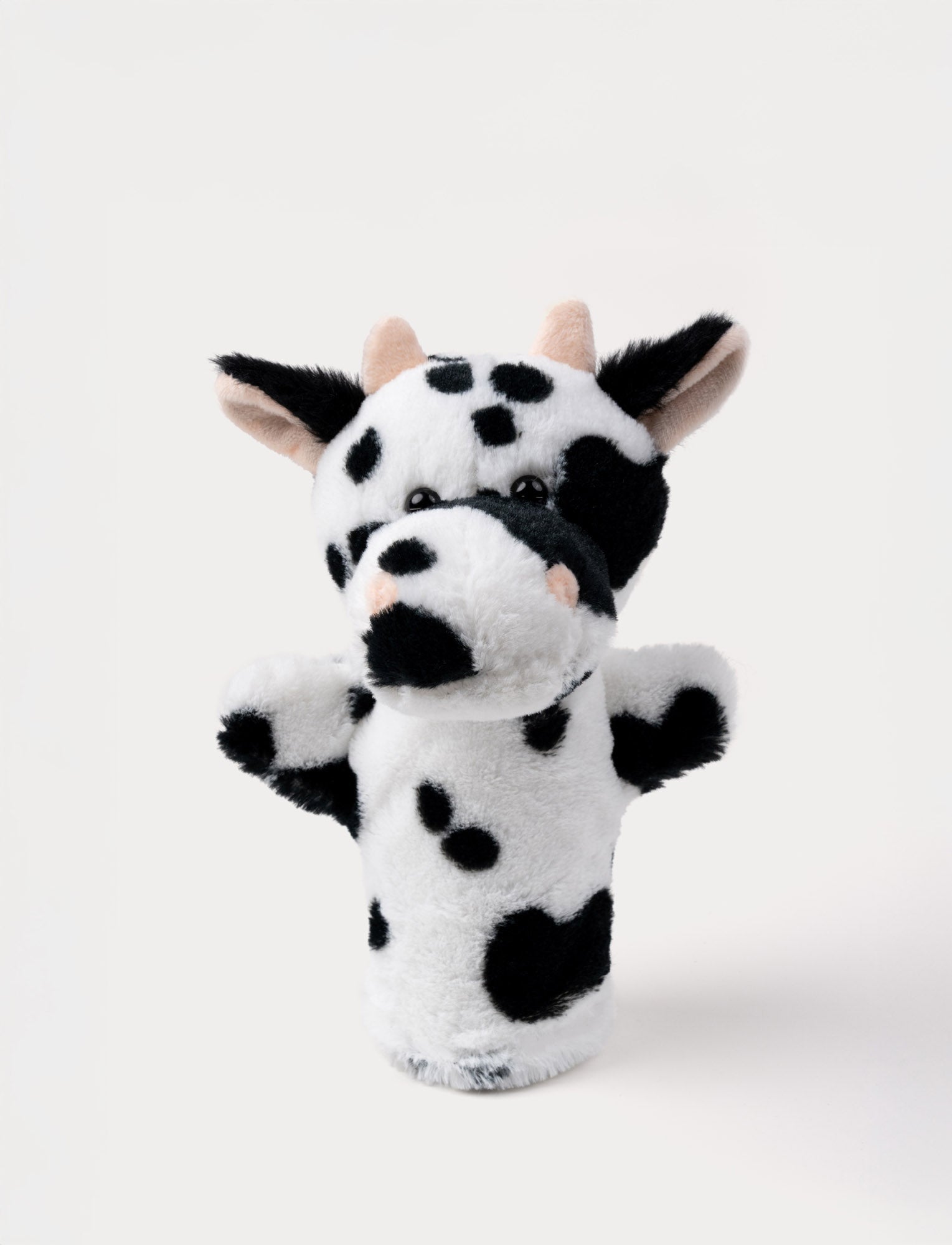  Image of Soft black and white cow hand puppet with pink horns, floppy ears, and shiny black eyes.