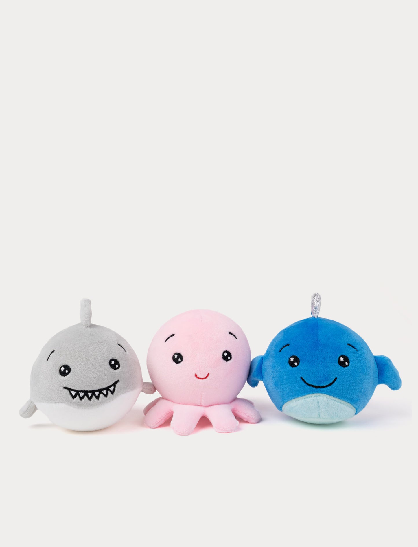Three squishy plush toys shaped like a shark, octopus, and whale on a white background