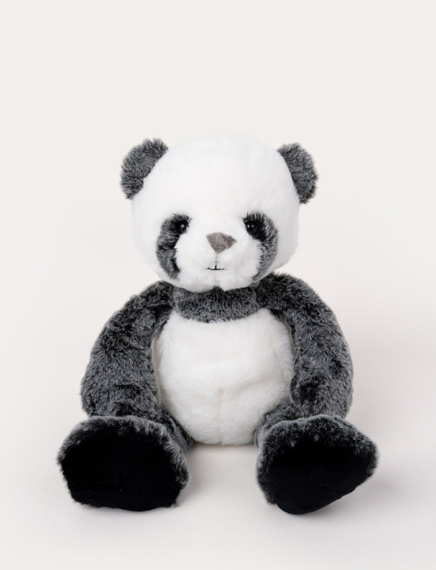 Soft, plush panda with black and white fur, black button eyes, and large black paws, sitting upright.