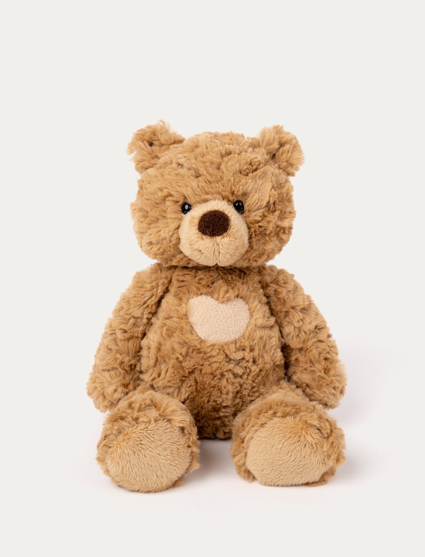 Soft brown teddy bear with a heart on its chest & black shiny eyes. 