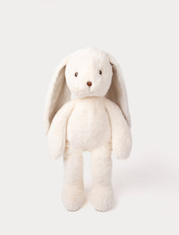 Large, cream-colored plush bunny with soft fur, long floppy ears, embroidered brown eyes, and a brown nose.