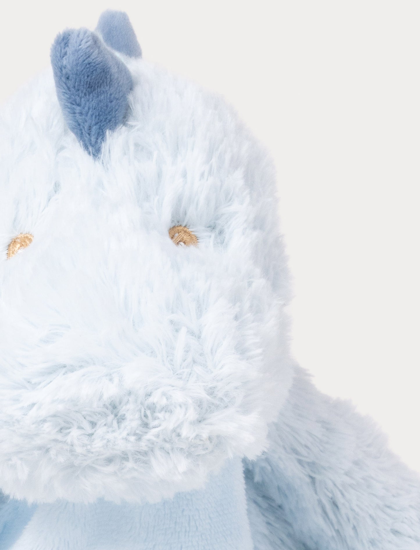 Soft baby blanket with a plush light blue dino head, drak blue spikes, and a cozy fabric body.