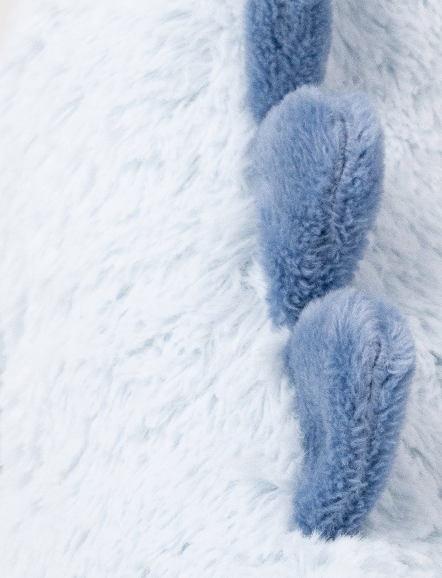 Soft plush light blue dino with dark blue fabric spikes and a fluffy texture.