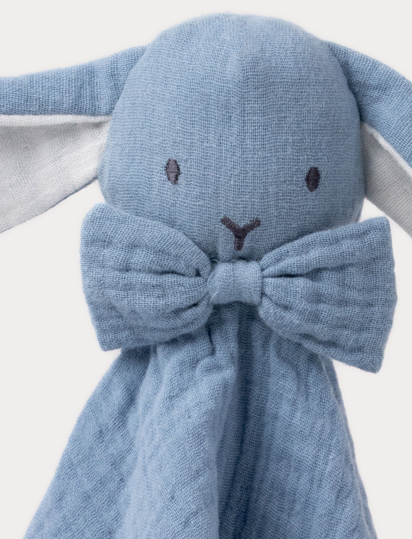 A soft blue baby blanket with a plush bunny,white details and cotton fabric