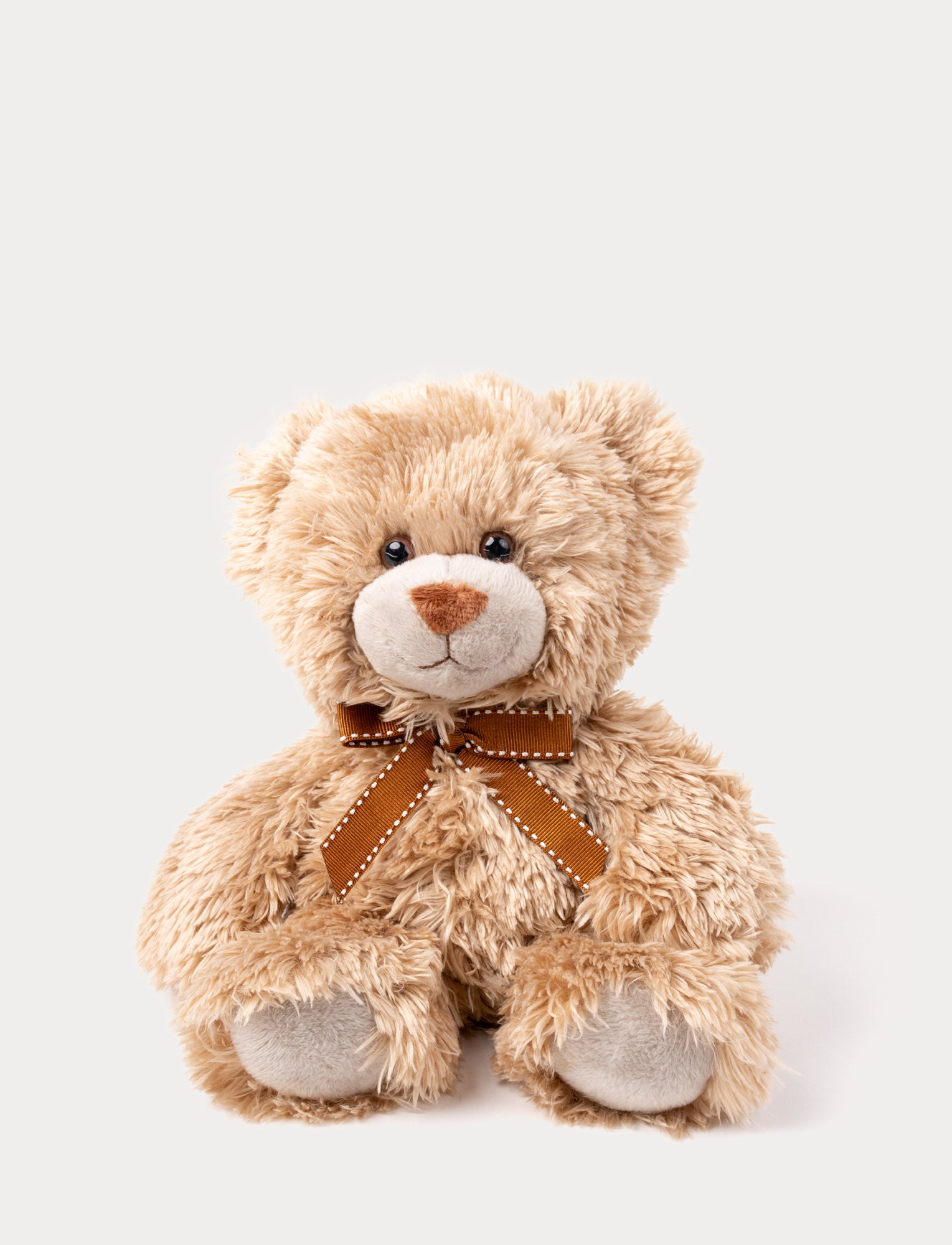  Image of A brown teddy bear with soft, shaggy fur, big eyes, and an elegant bow around his neck.