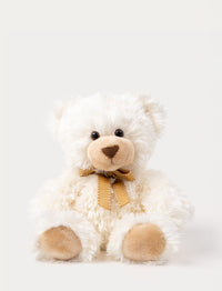 A white teddy bear with soft fur, big eyes, and an elegant bow around his neck.