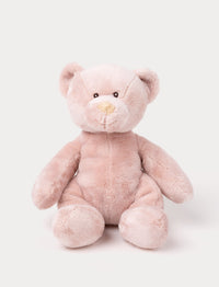 A small teddy bear with short, velvety pink fur and carefully stitched details.