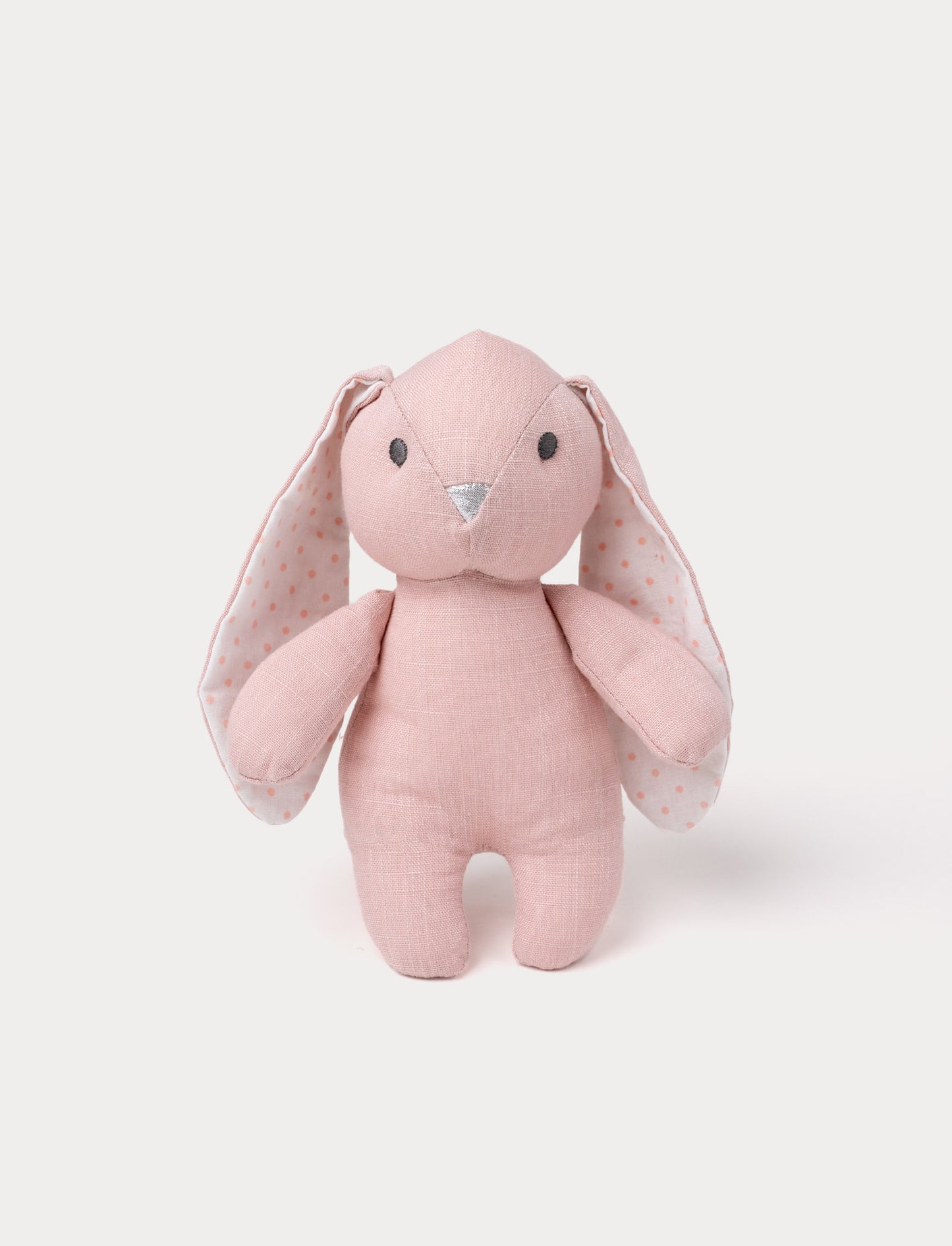 A bunny with soft dusty pink fur, large white ears with pink polka dots, and a silver nose.