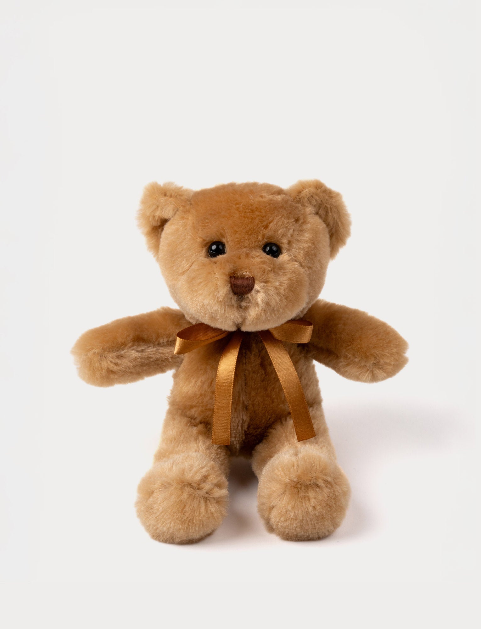  Image of A teddy bear with warm brown fur, an embroidered nose, and an adorable satin bow.