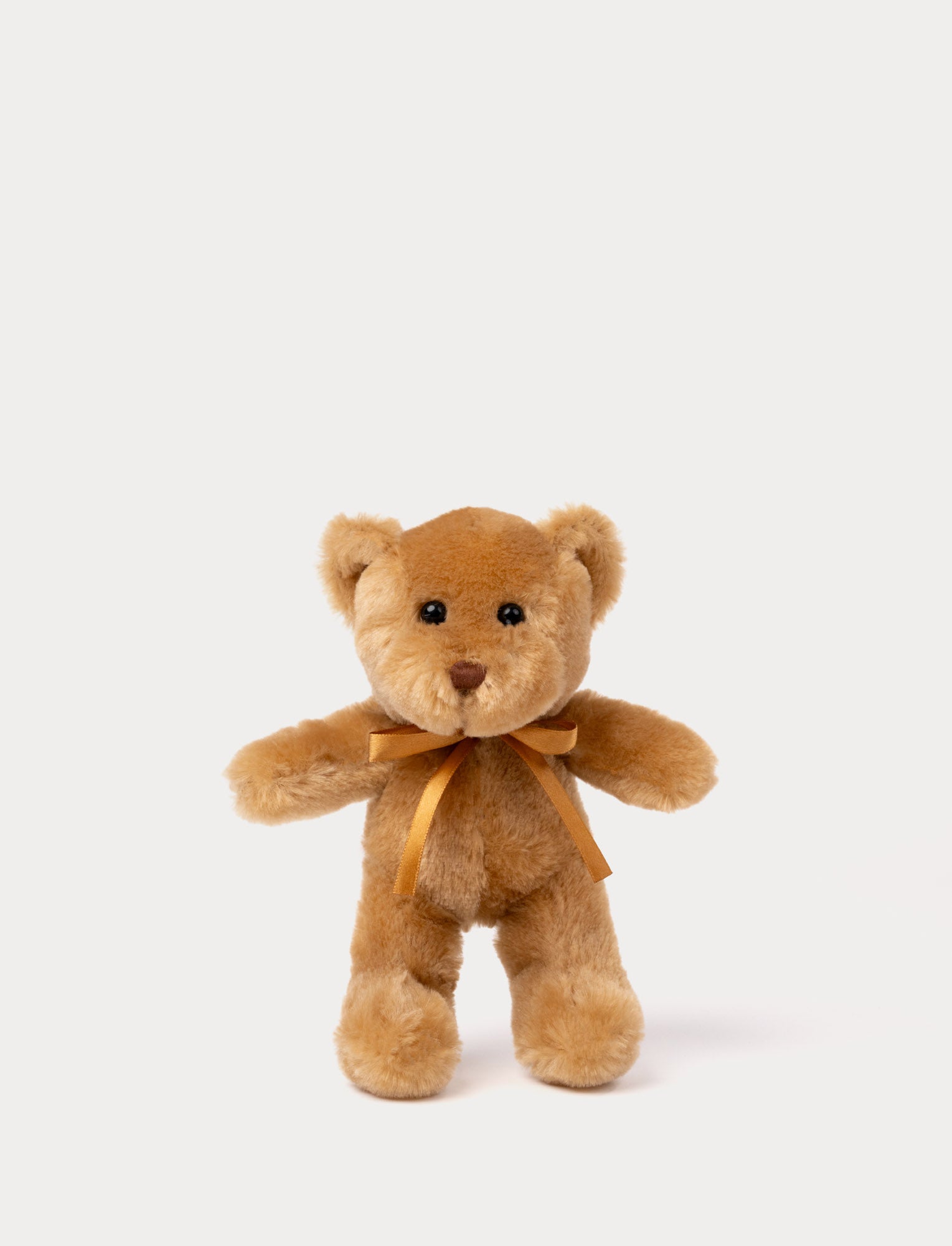  Image of A teddy bear with warm brown fur, an embroidered nose, and an adorable satin bow.