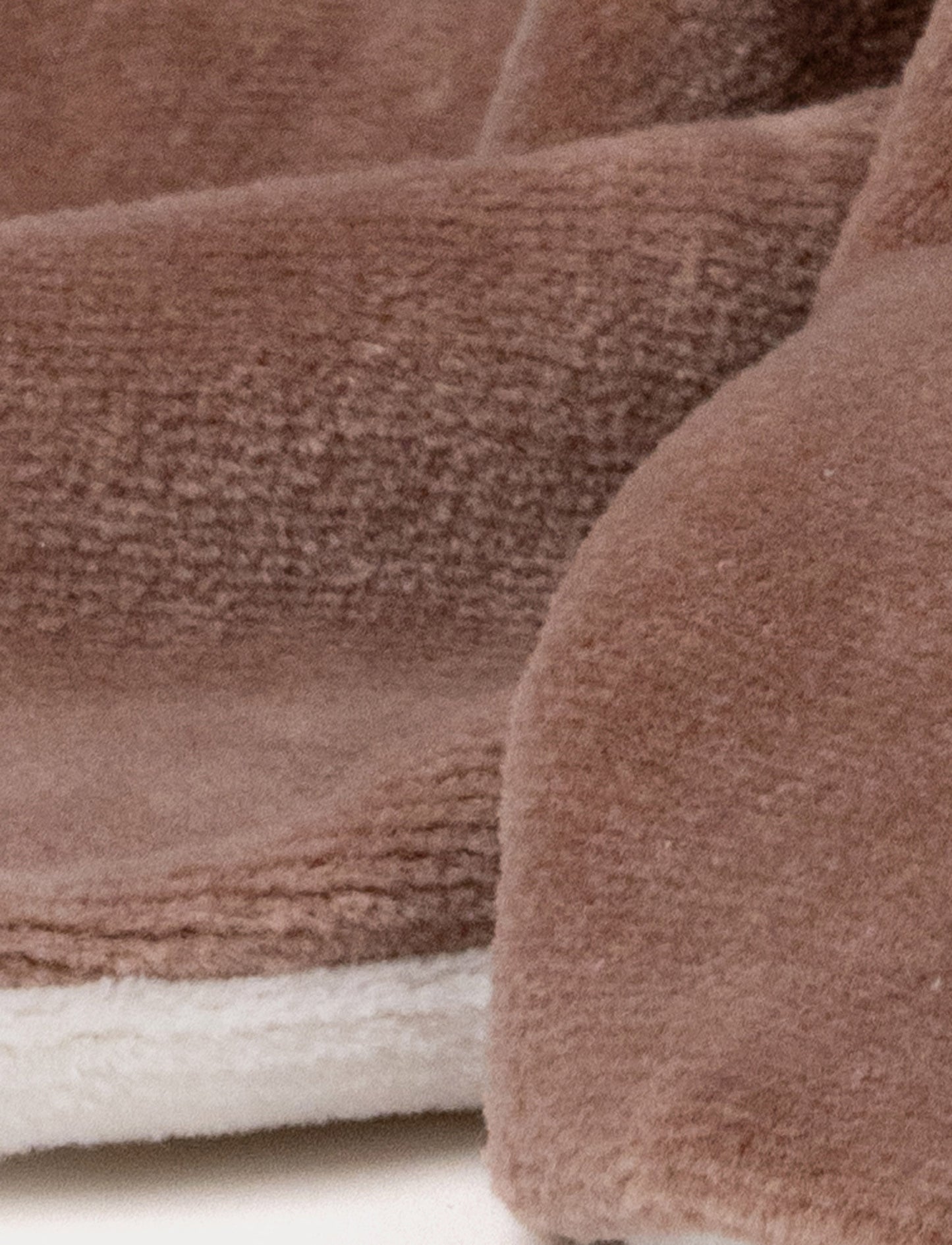 A soft brown moose baby blanket with white antlers, a stitched face and white and brown details.