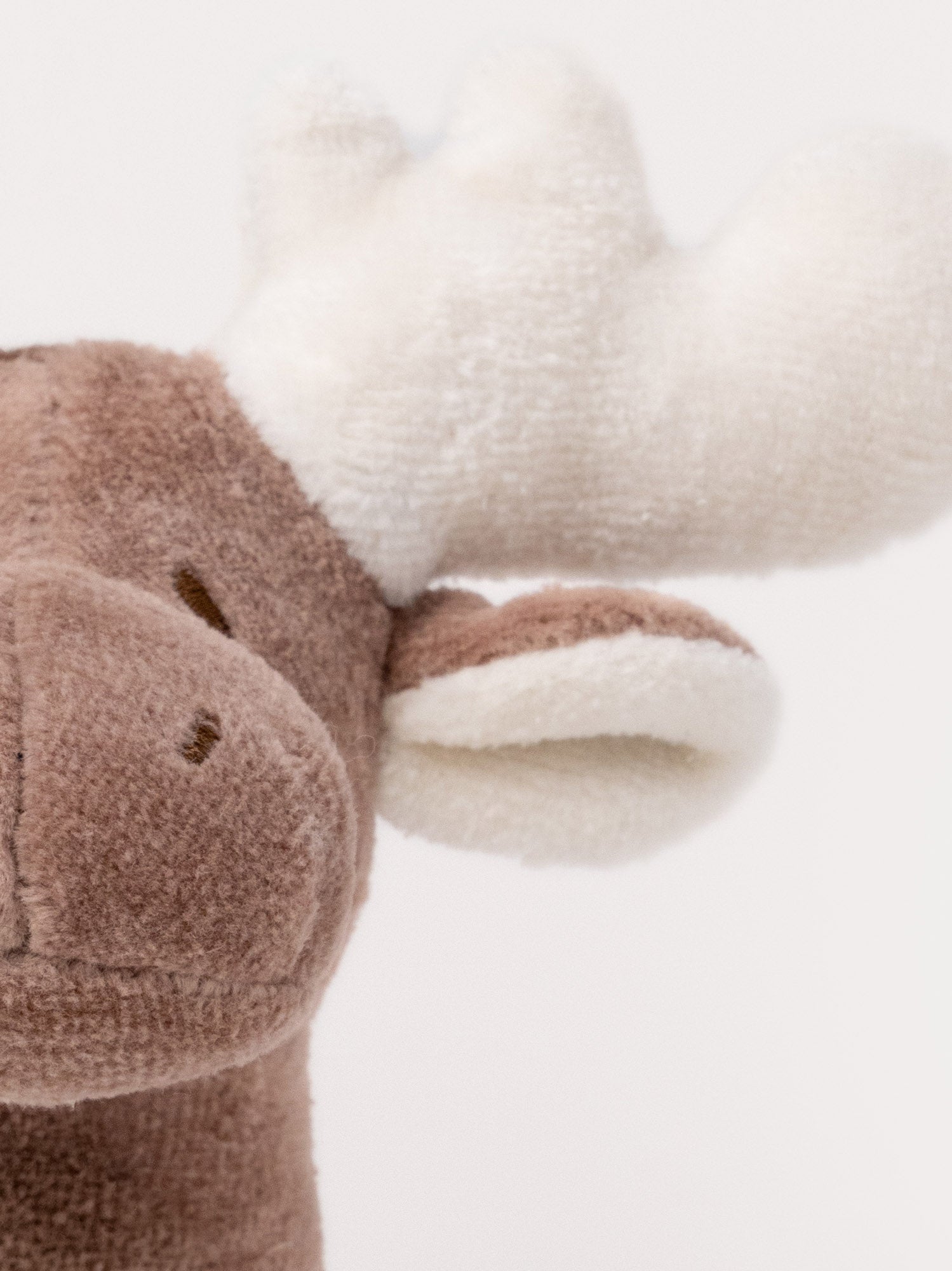  Image of A plush moose rattle with a soft brown body, white antlers, and a stitched face