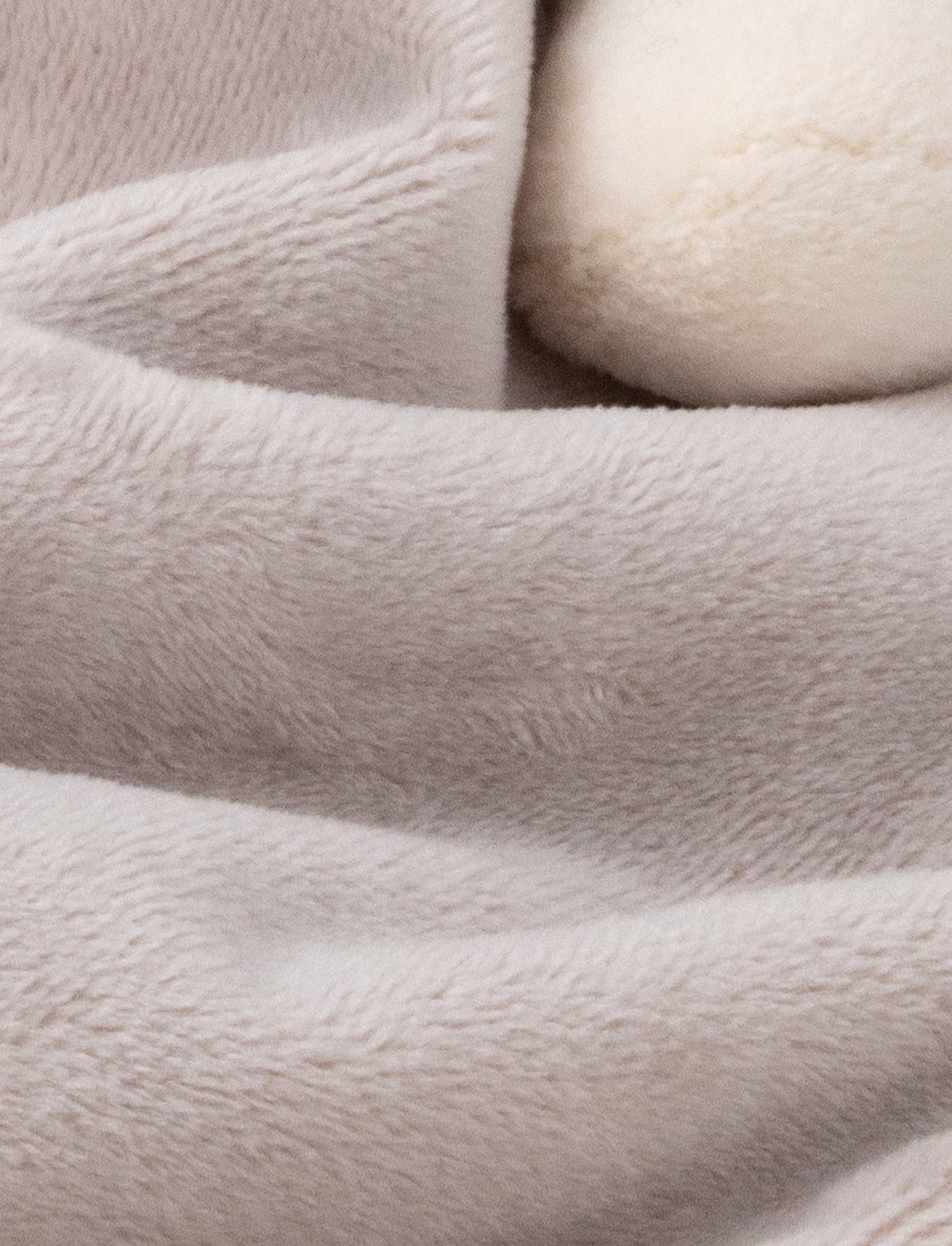 Soft baby blanket with a plush gray dino head, white spikes, and cream-trimmed edges.