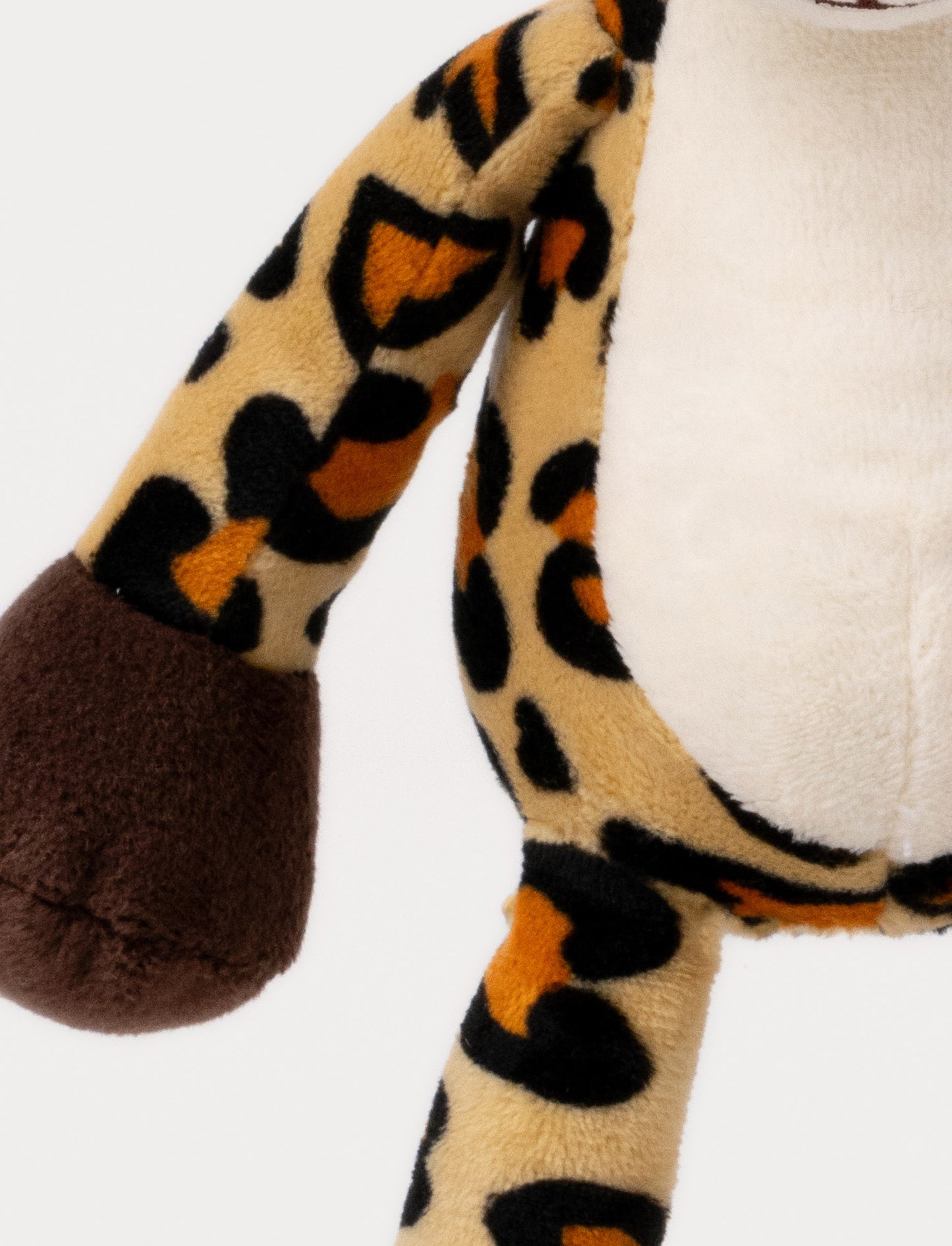A plush leopard music box with spots, a white belly, brown paws and a hanging loop.