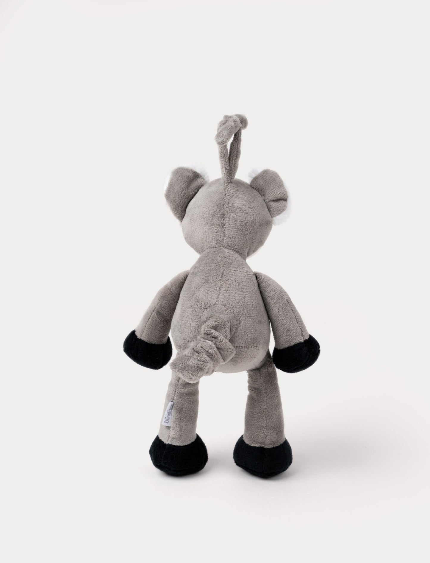 A plush koala music box with a white belly, black paws, and a hanging loop