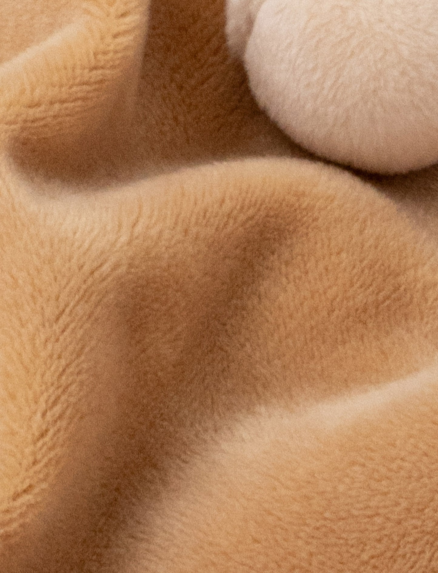 Soft baby blanket with a plush brown bear head, closed eyes, and cream-trimmed edges.