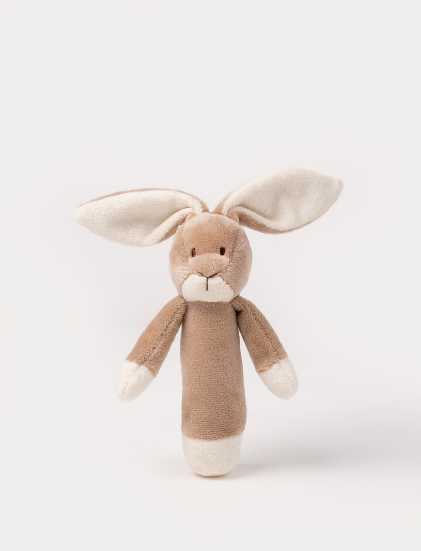 Soft plush bunny rattle with a light brown body, long floppy ears, embroidered eyes, and white accents on the hands and base.