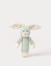 Soft plush bunny rattle with a light green body, long floppy ears, embroidered eyes, and white accents on the hands and base.