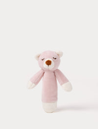 Soft plush bear rattle with a dusty pink body, embroidered sleeping eyes, a white muzzle, and white accents on the hands and base.