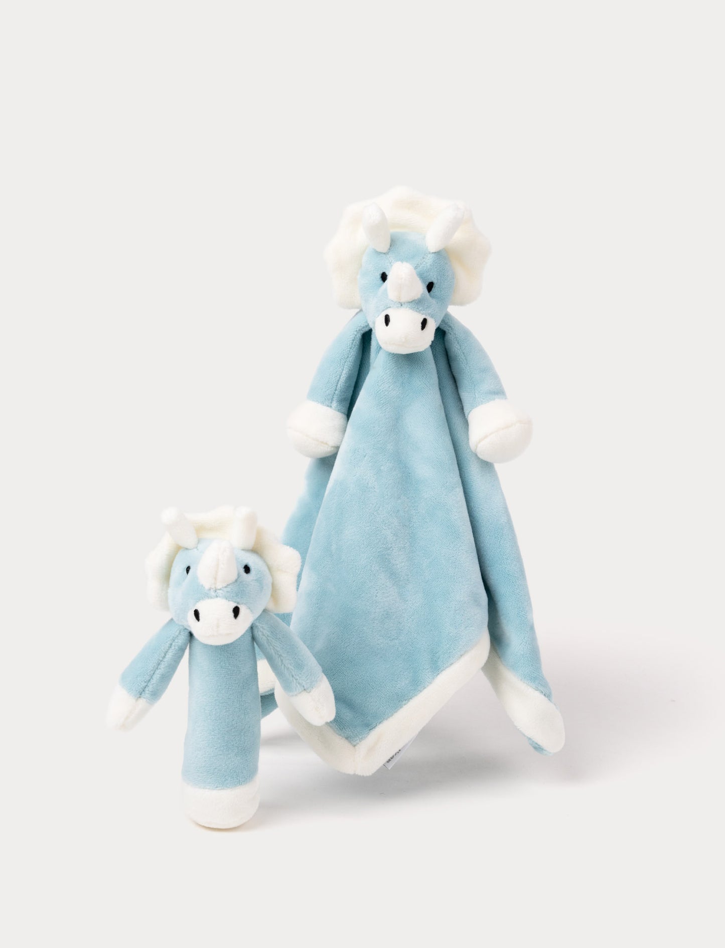 Soft blue triceratops plush set with white horns, featuring a cuddle blanket and matching rattle toy.