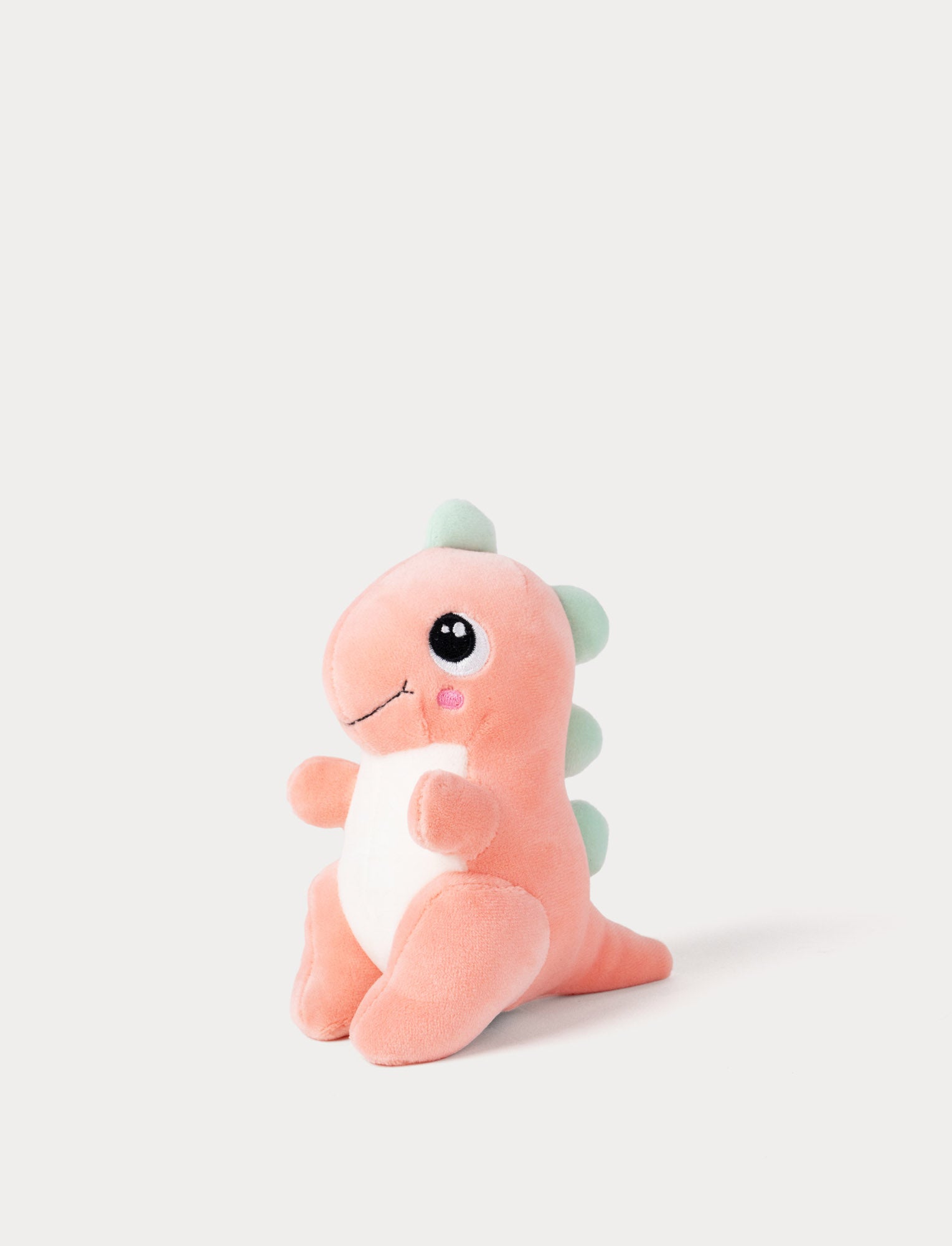 Image of Plush toy dinosaur with pink body and green spikes on a white background