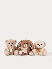 Three plush toys - a bear, a rabbit, and a dog, with bows, sitting together on a white background.