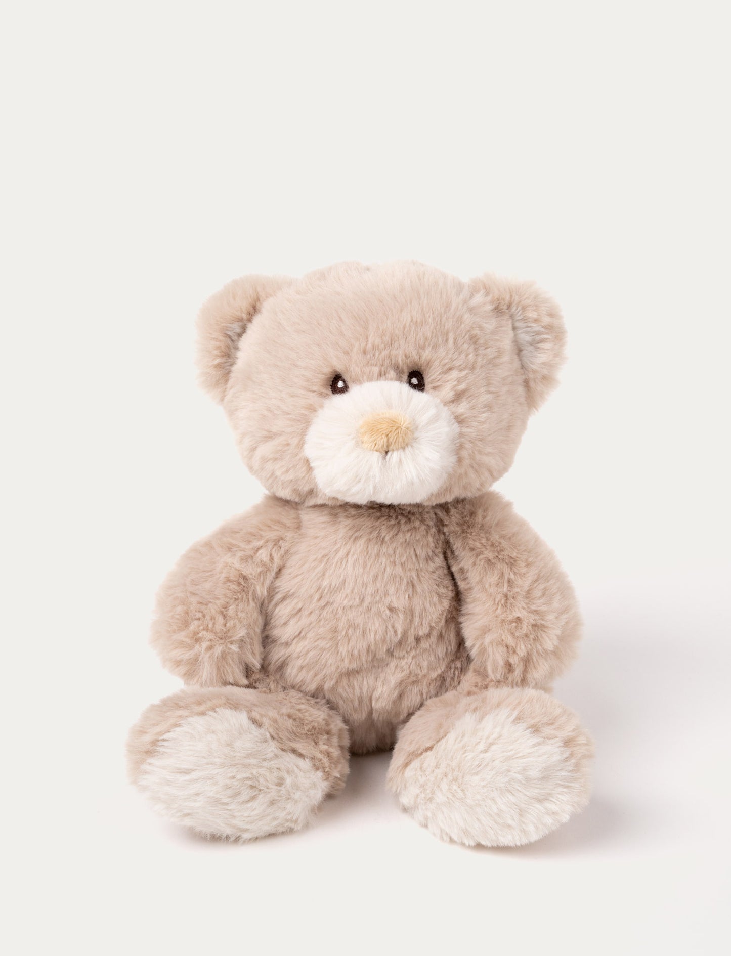 A beige teddy bear with luxurious soft material, faux suede detail on its back, and embroidered eyes.