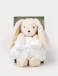 Gift set with a cream-colored plush bunny holding a soft white blanket tied with a satin ribbon, presented in a green box.