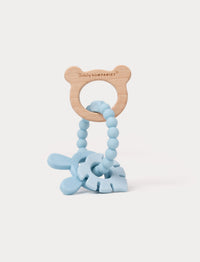 Wooden and silicone baby teething toy in blue with a bear-shaped handle, beaded loop, and soft textured shapes.
