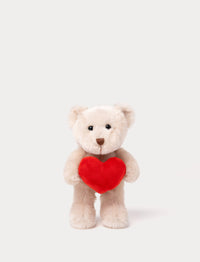 Soft beige teddy bear plush toy holding a bright red heart