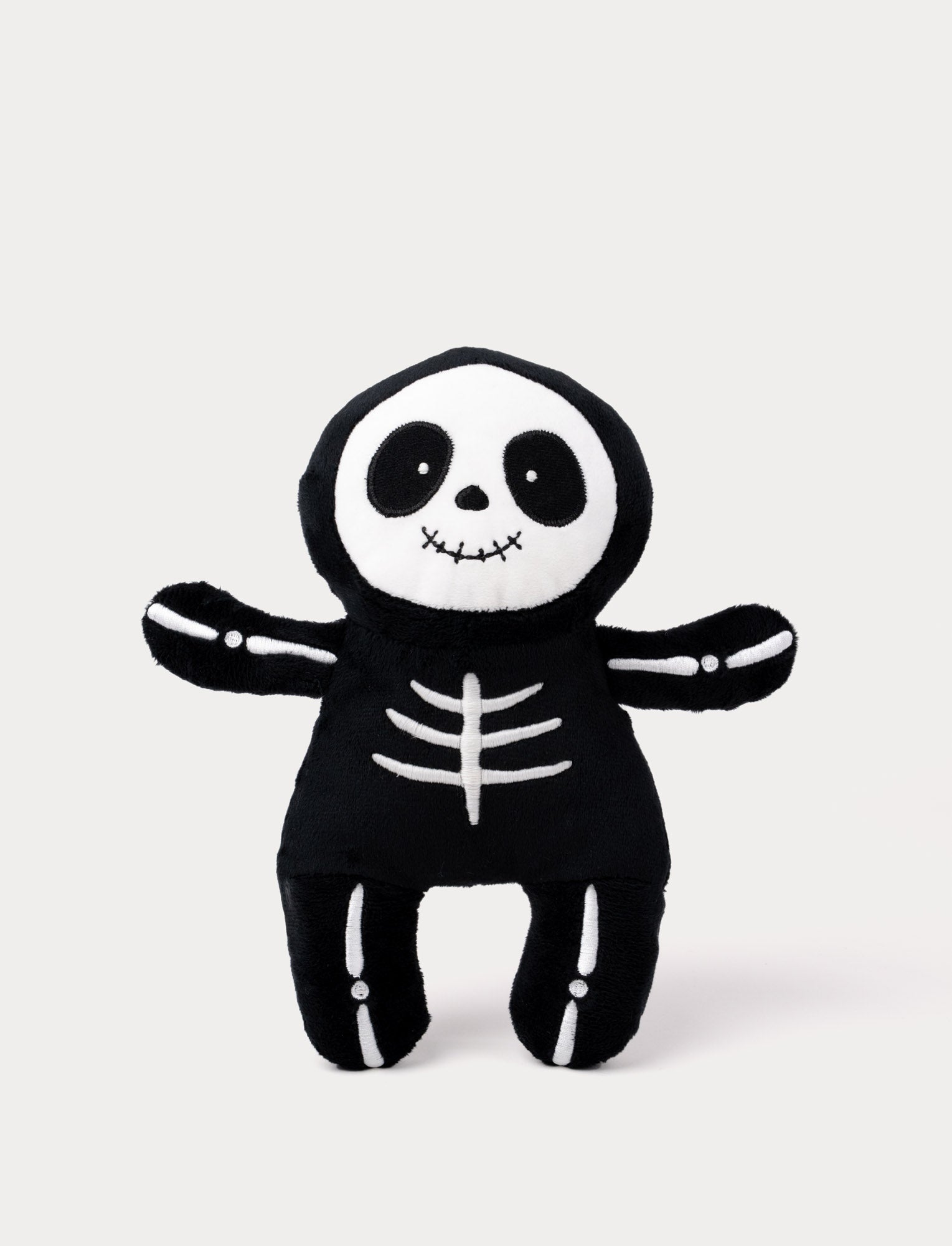  Image of Soft black skeleton plush toy with glow-in-the-dark white effect.