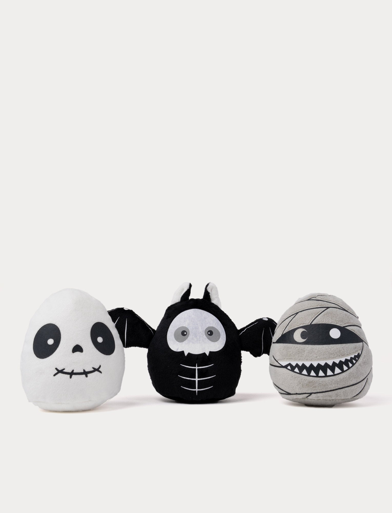  Image of Three Halloween-themed plush toys shaped like a ghost, bat, and mummy. Glow-in-the-Dark effect