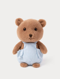 Stuffed teddy bear wearing a light blue outfit on a white background