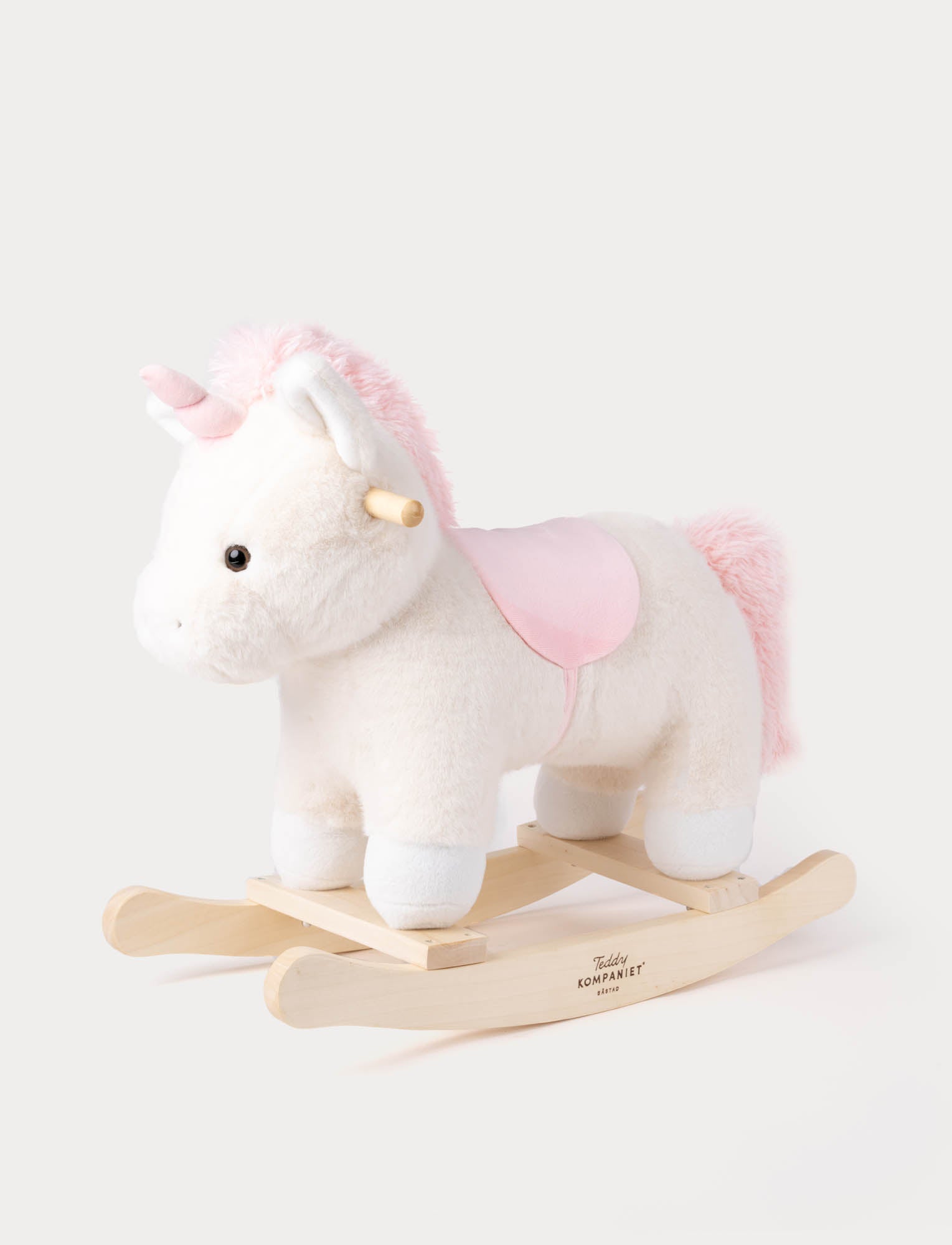  Image of Plush white unicorn rocking toy with pink mane, tail, horn, and saddle on a wooden rocker base
