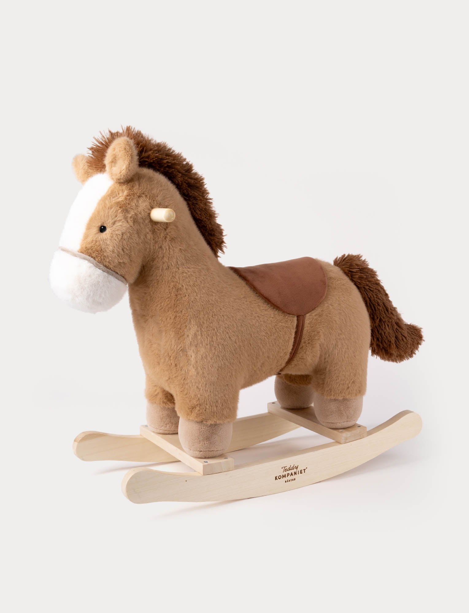  Image of Plush brown horse rocking toy with white face, soft saddle, and wooden rocker base.